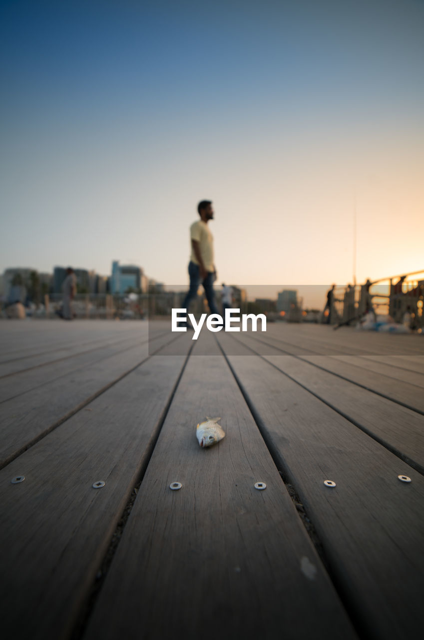 SURFACE LEVEL VIEW OF MAN ON PIER