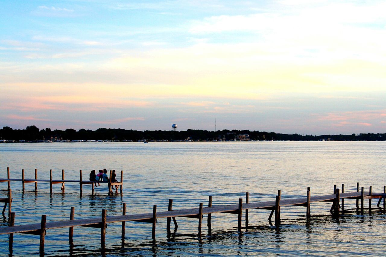 PEOPLE ON LAKE AGAINST SKY