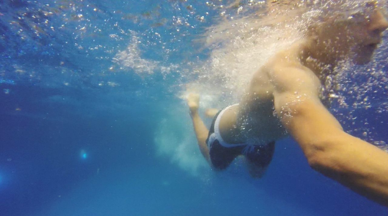 Shirtless man swimming undersea