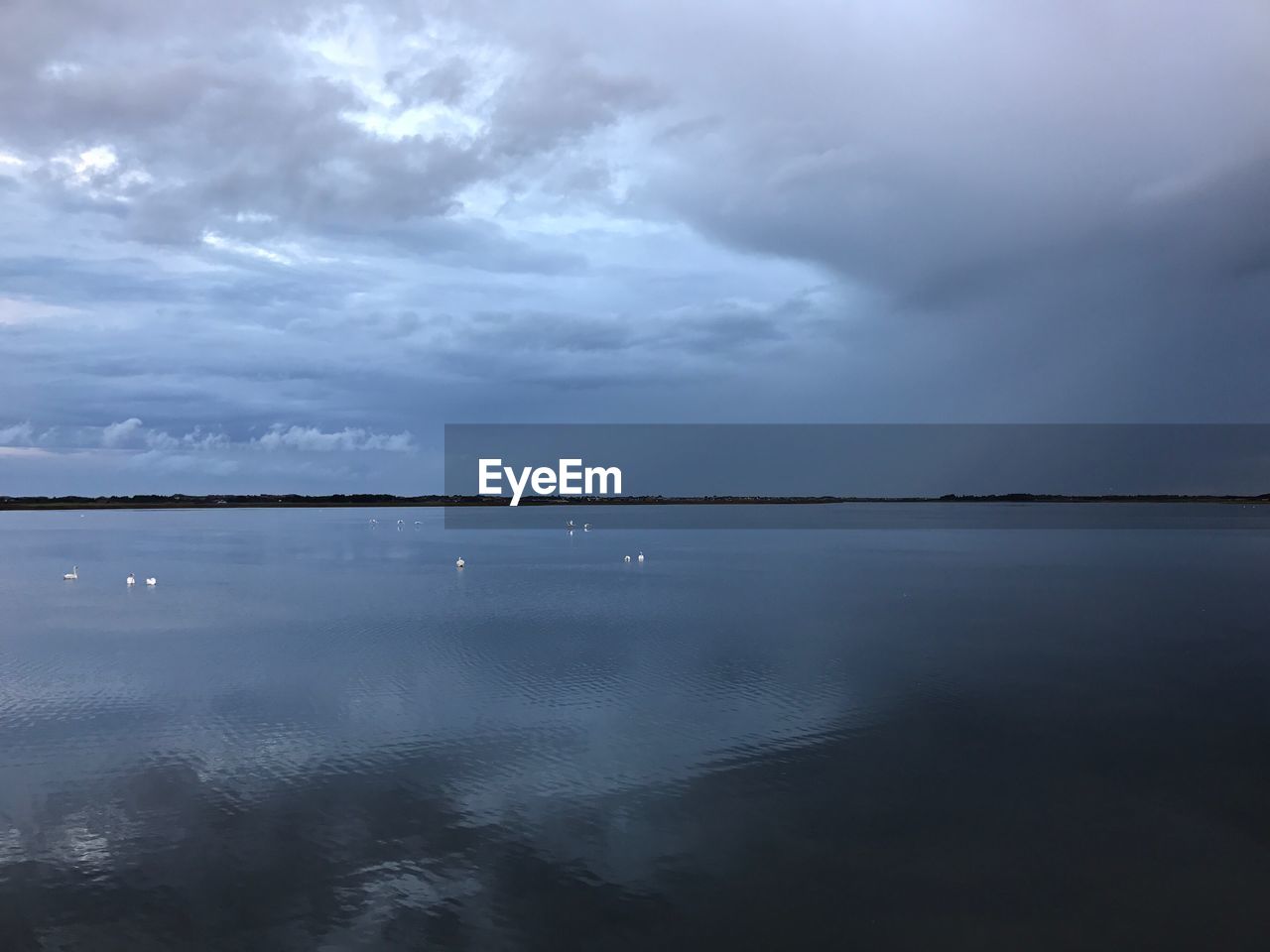 SCENIC VIEW OF LAKE AGAINST STORM CLOUDS