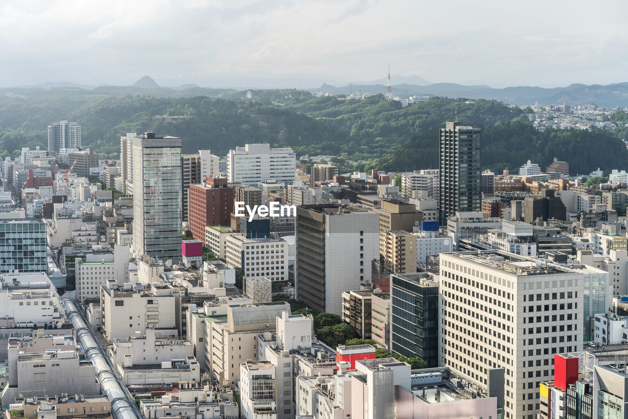 HIGH ANGLE VIEW OF BUILDINGS AGAINST SKY IN CITY