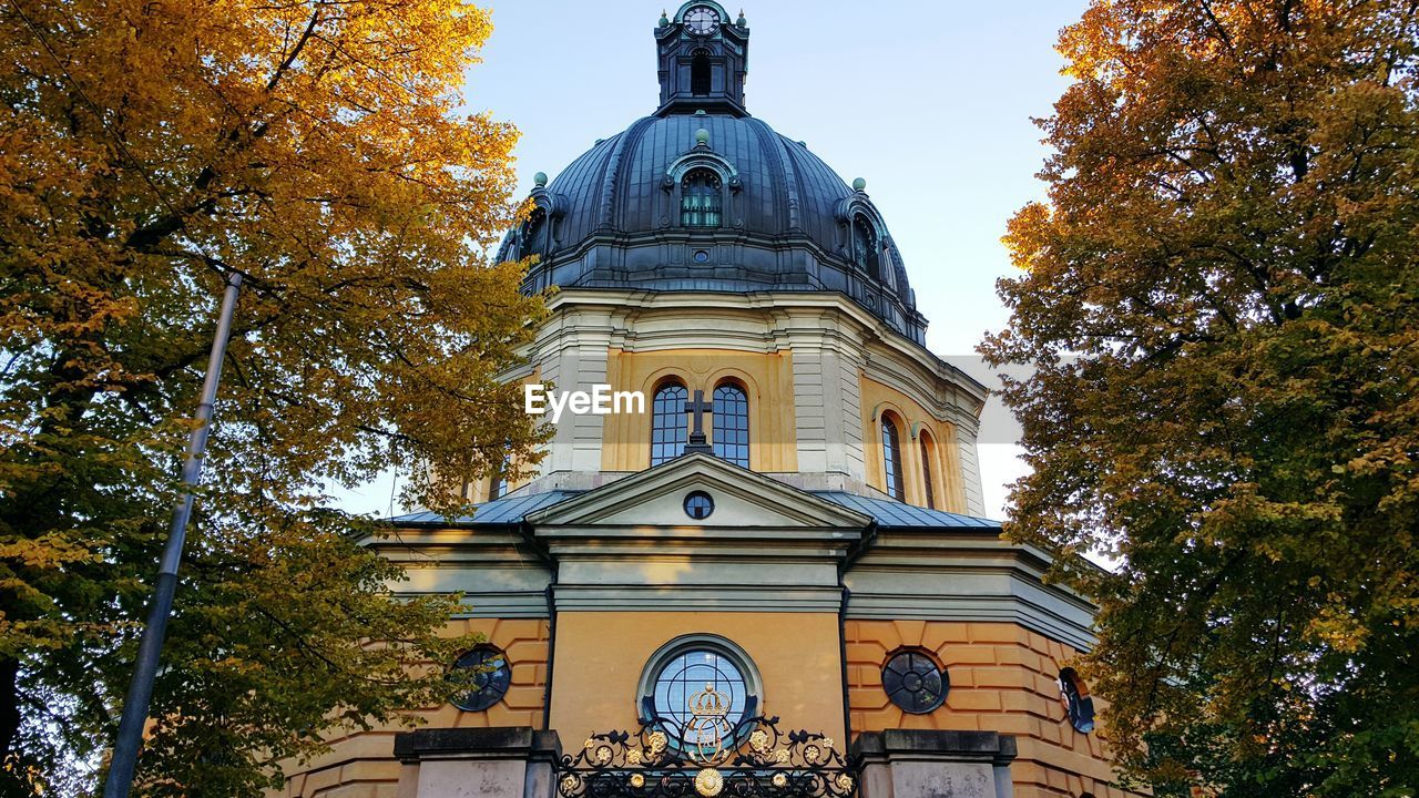 LOW ANGLE VIEW OF CHURCH WITH TREES IN BACKGROUND