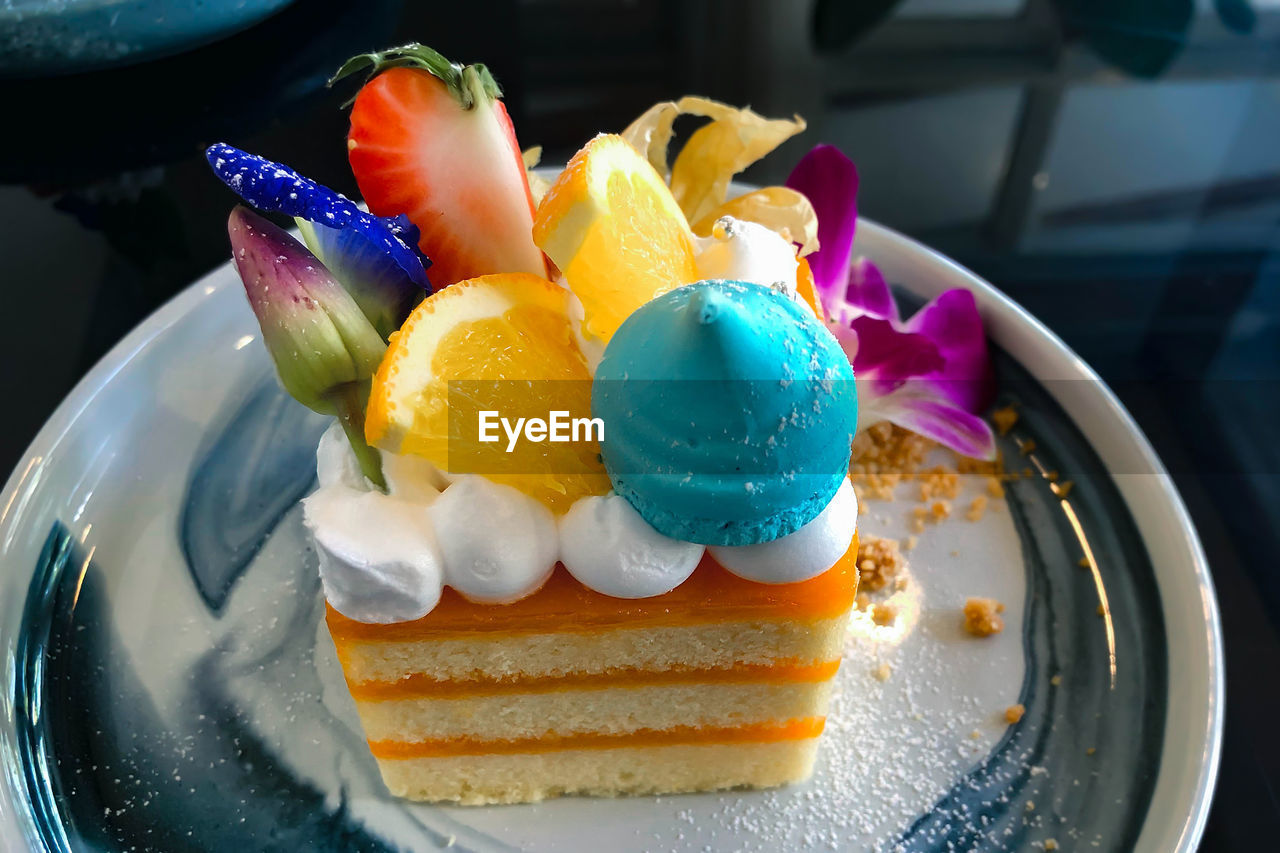 Orange cake with orange topping on plate ready to eat