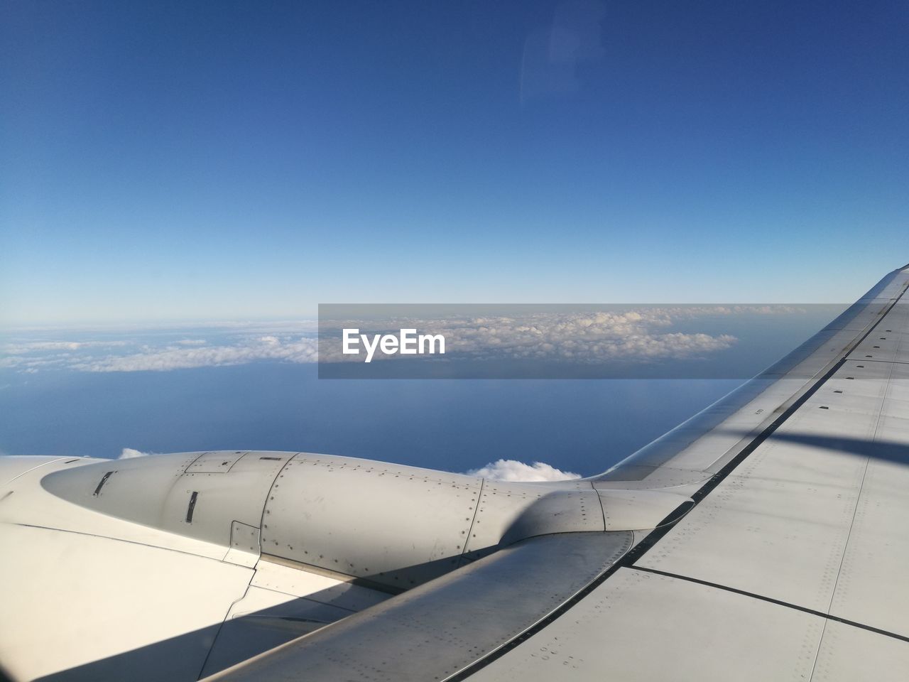 AERIAL VIEW OF AIRCRAFT WING AGAINST SKY