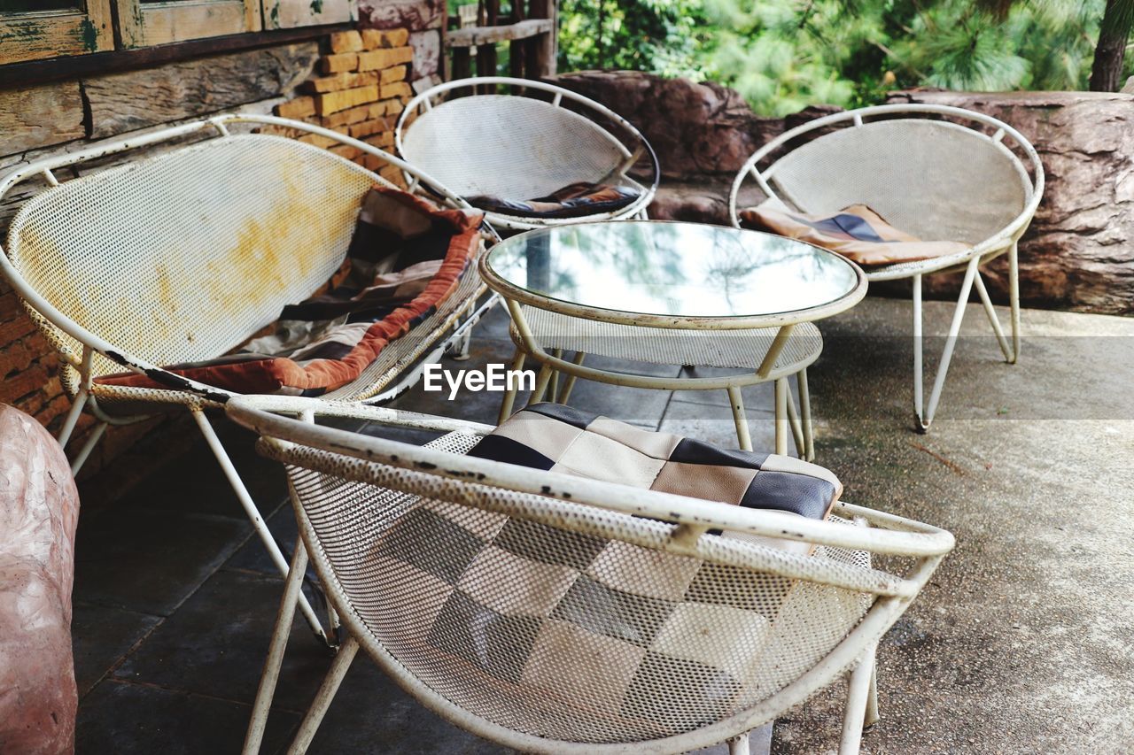 High angle view of old chairs and table in abandoned building