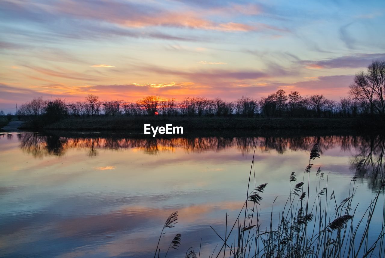 SCENIC VIEW OF LAKE AGAINST CLOUDY SKY