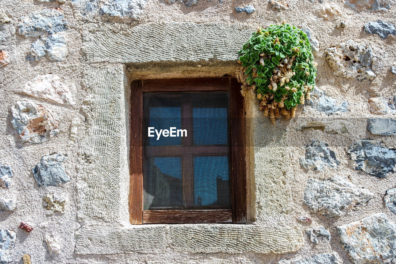 LOW ANGLE VIEW OF WINDOW ON OLD BUILDING