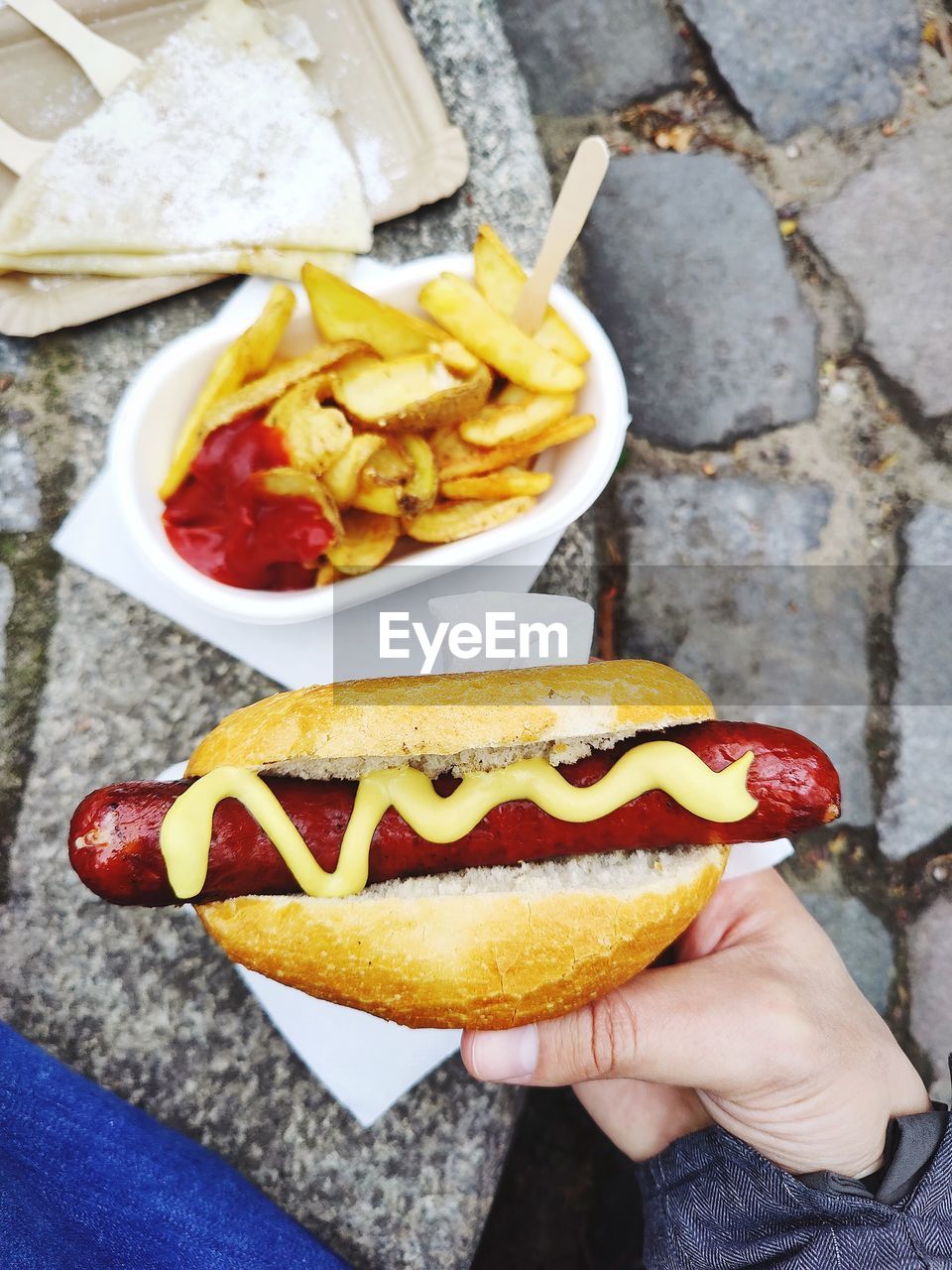 Close-up of hand holding sausage in bread