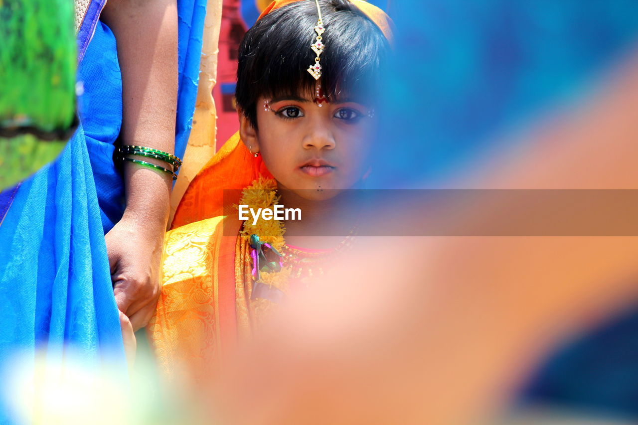 Portrait of girl with mother in traditional clothing during festival