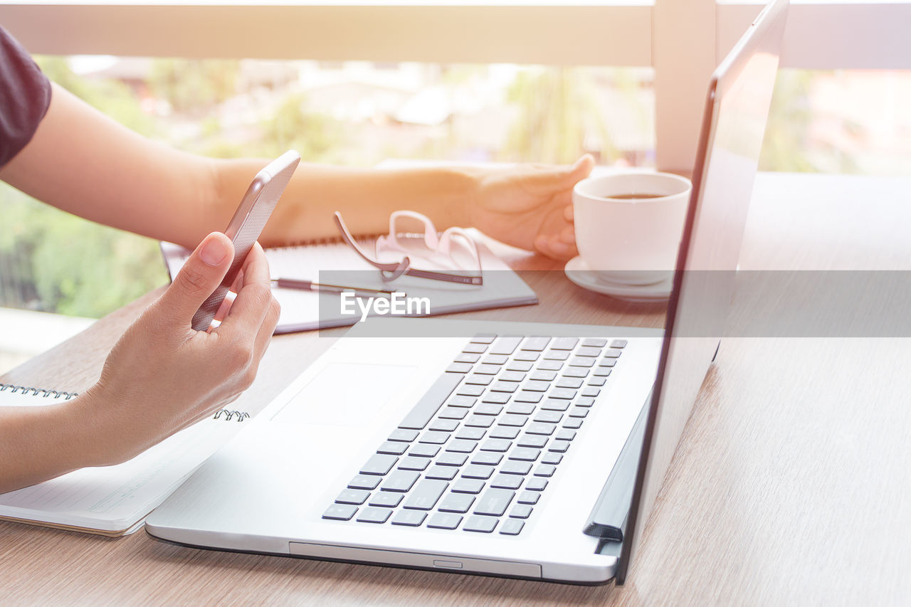 Businesswoman using technologies at table in cafe