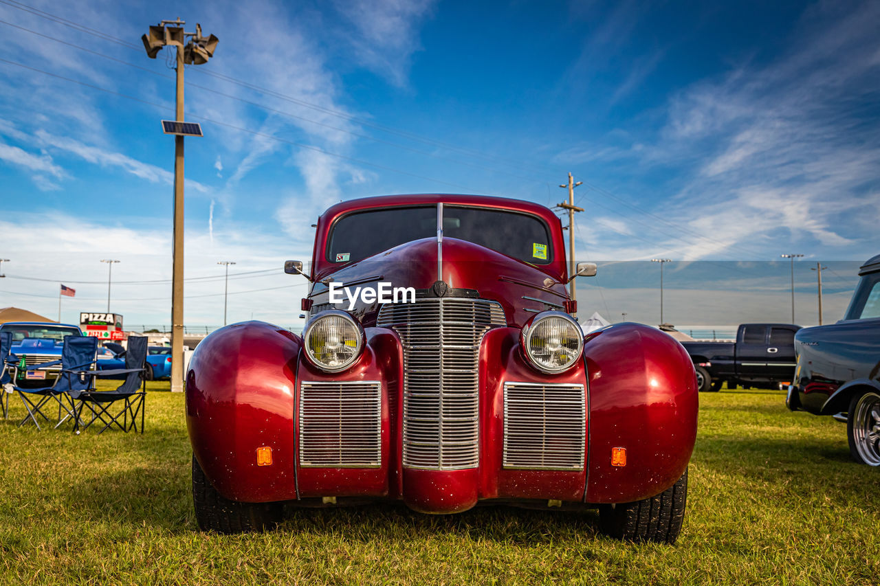 RED VINTAGE CAR ON FIELD