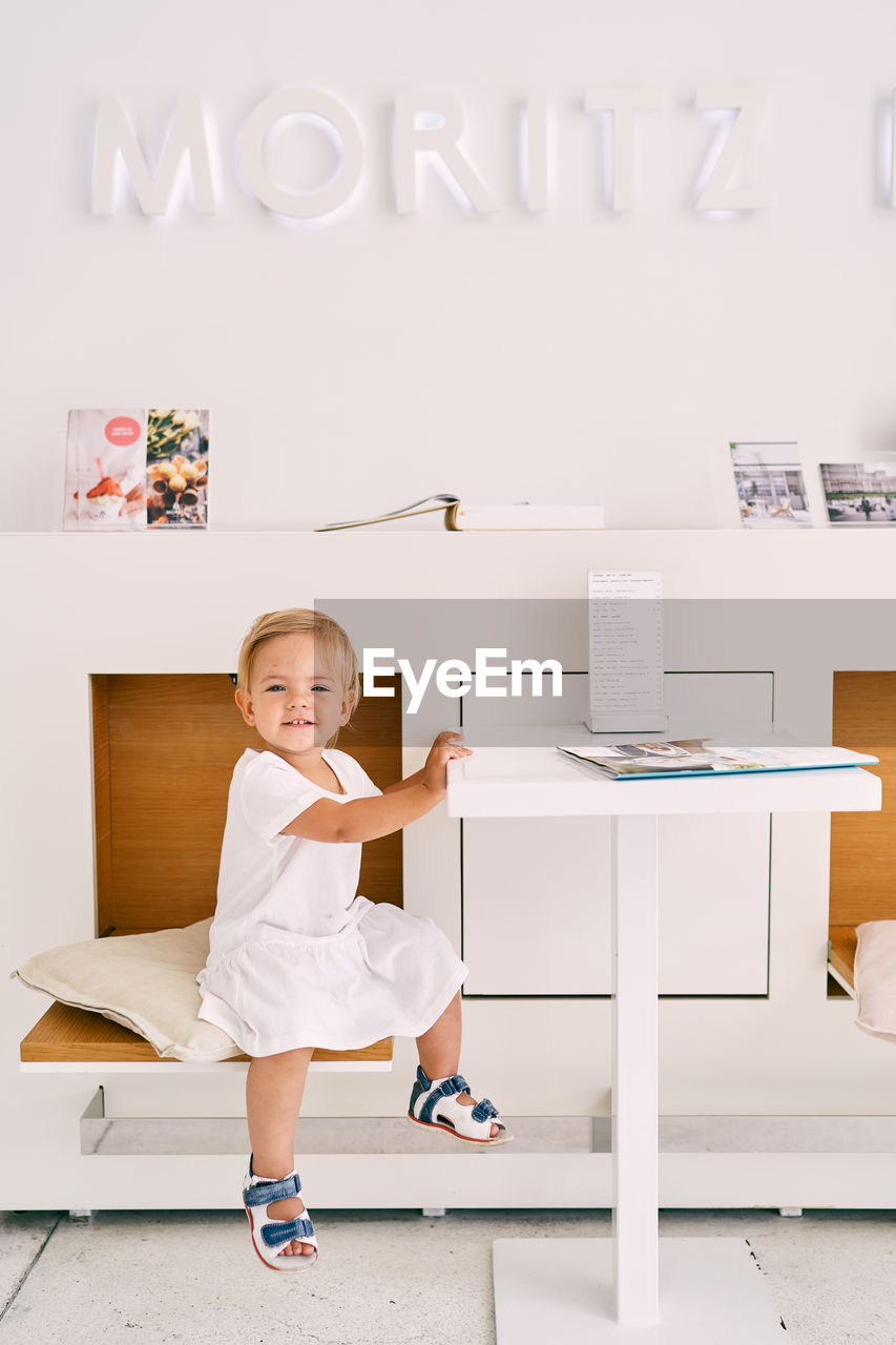 PORTRAIT OF HAPPY GIRL ON TABLE