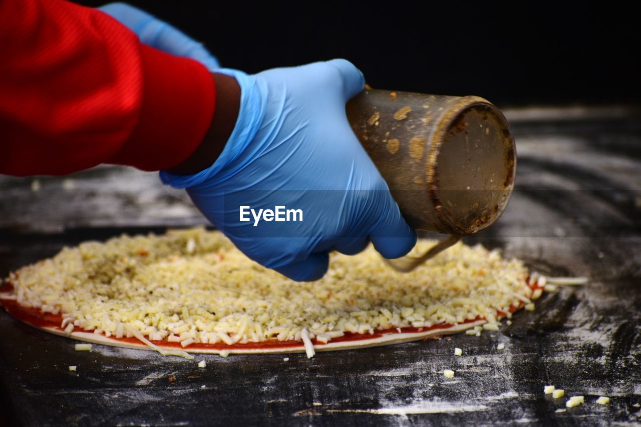 MIDSECTION OF PERSON PREPARING FOOD IN CONTAINER