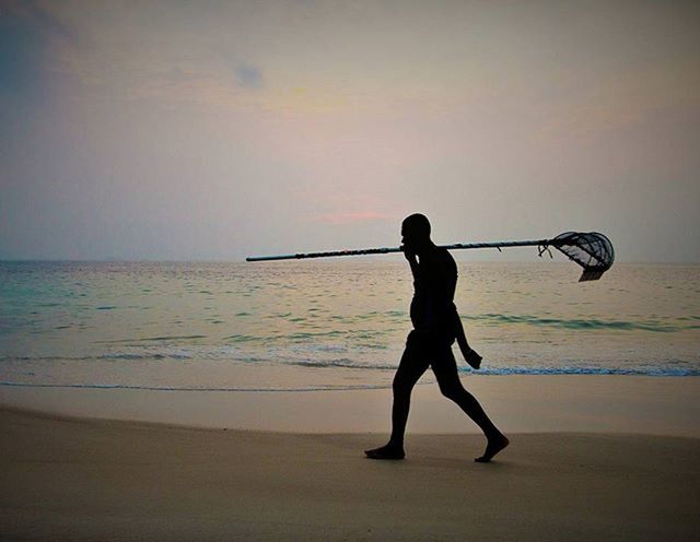 SILHOUETTE OF WOMAN ON BEACH AT SUNSET