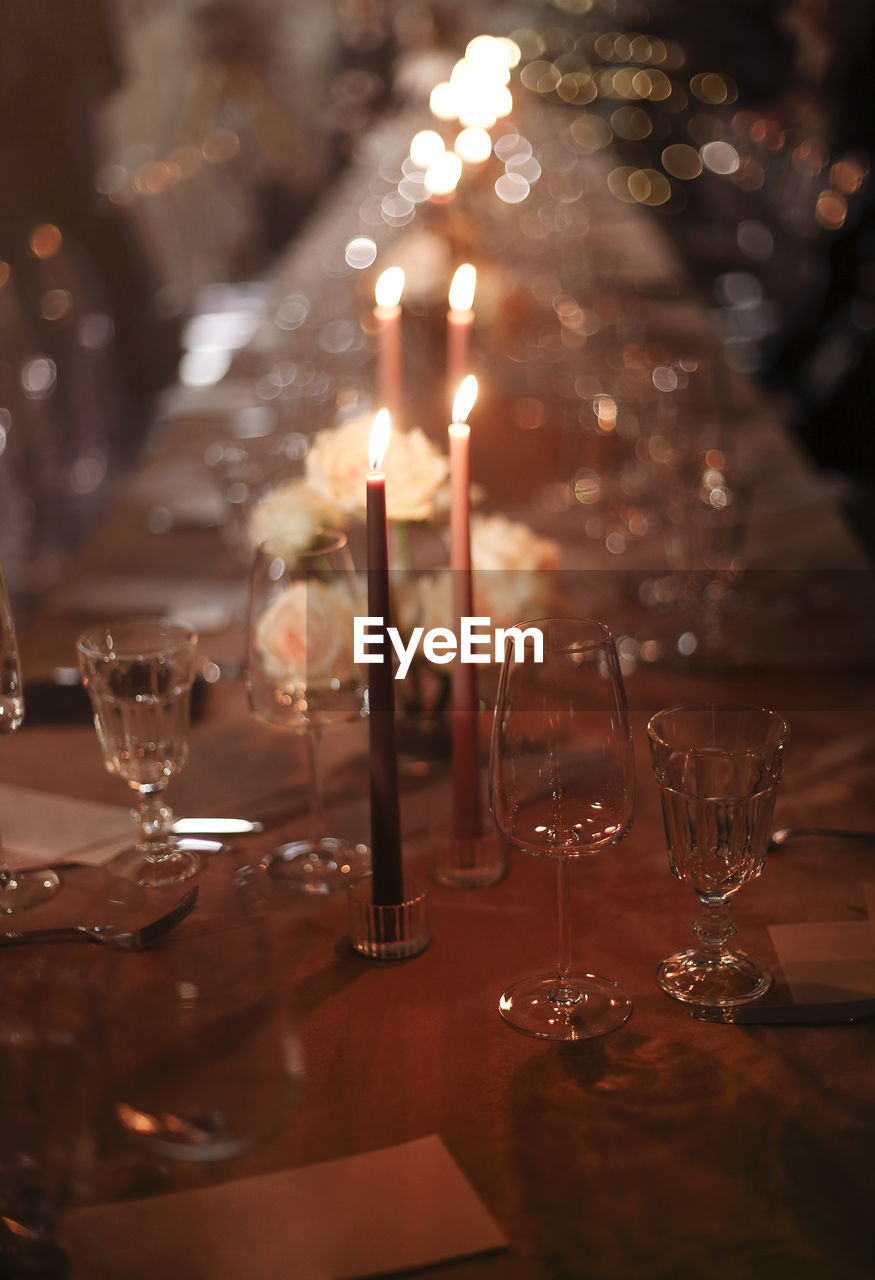 Close-up of wine glass on table with candles in restaurant