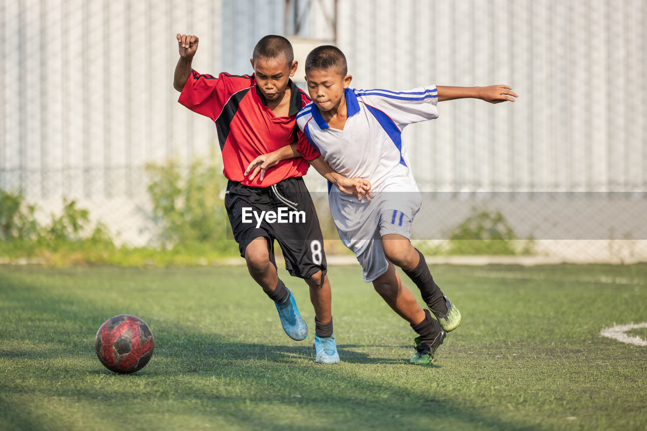 Full length of man playing soccer on field