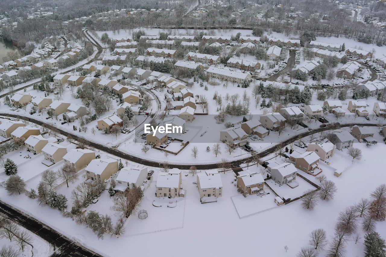 HIGH ANGLE VIEW OF SNOW COVERED TREES AND BUILDINGS