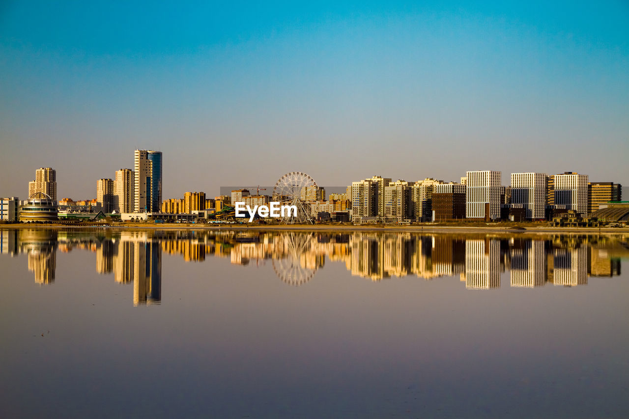 Reflection of buildings in lake against sky