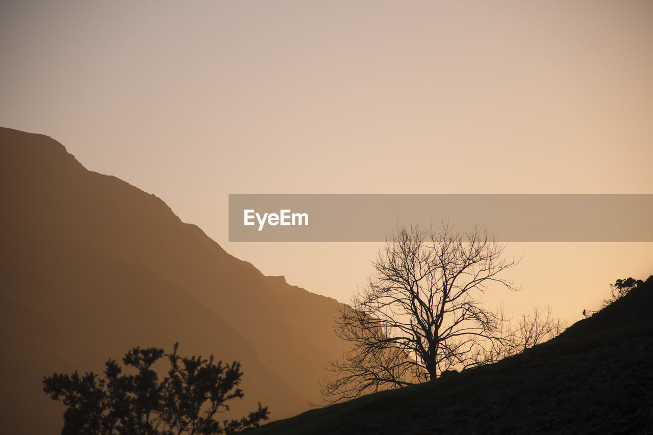 Scenic view of mountains against clear sky during sunset