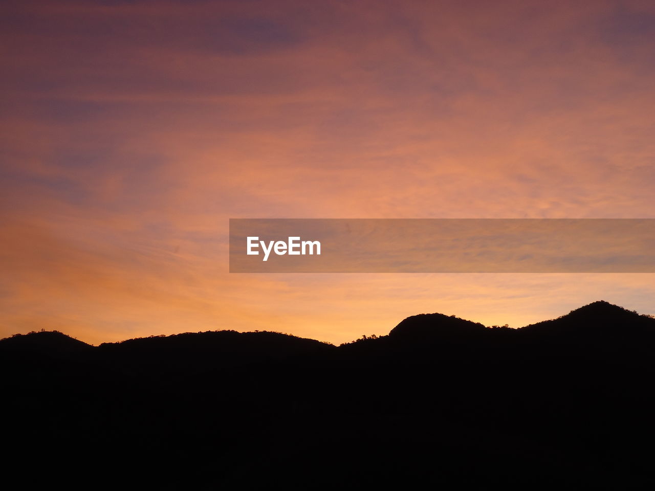 Silhouette mountains against sky at dusk