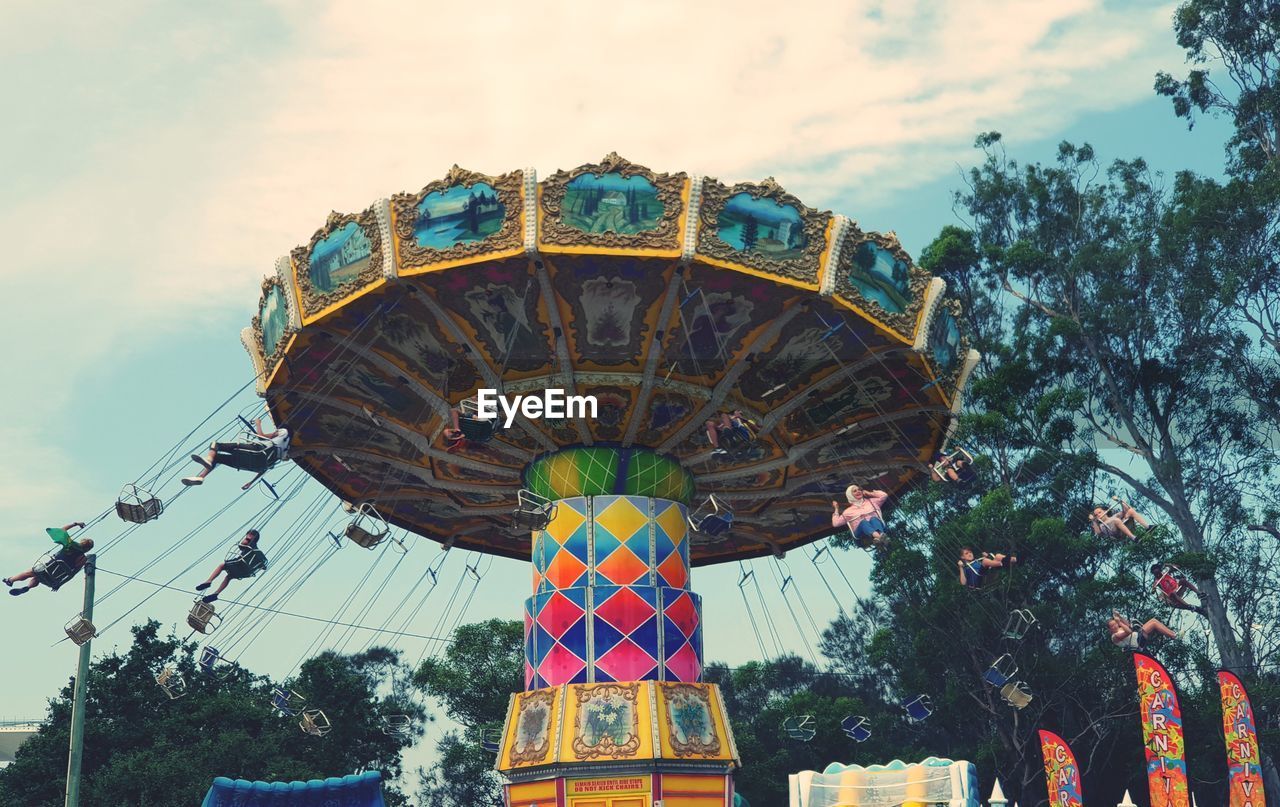 LOW ANGLE VIEW OF CAROUSEL RIDE AGAINST SKY