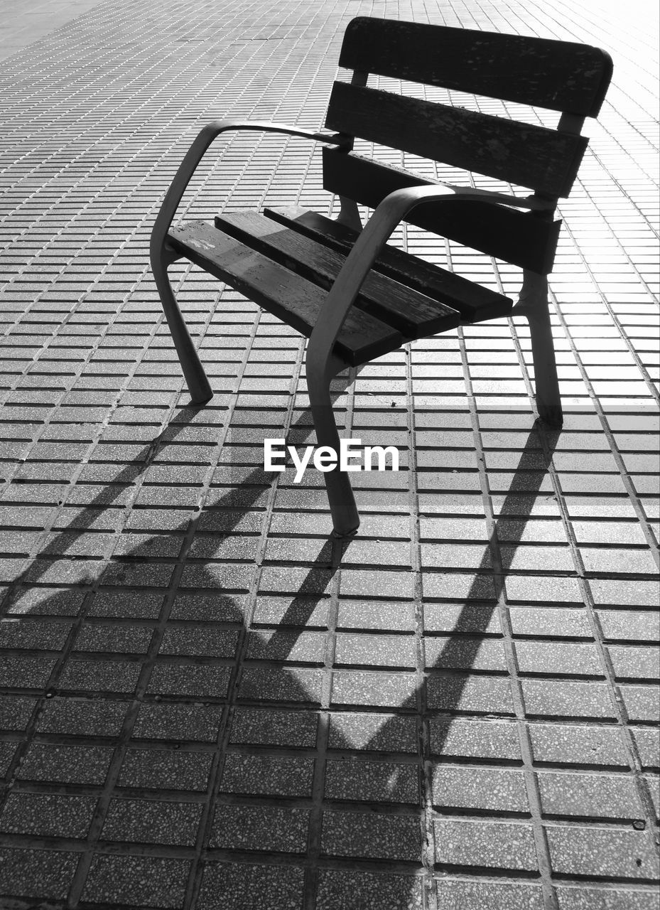 HIGH ANGLE VIEW OF BENCH ON FOOTPATH