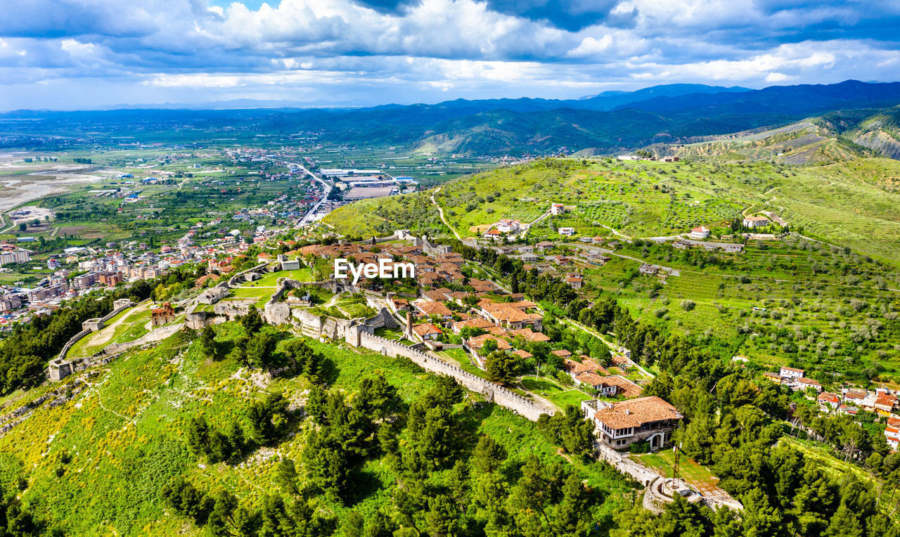 HIGH ANGLE VIEW OF TOWNSCAPE AND PLANTS AGAINST SKY