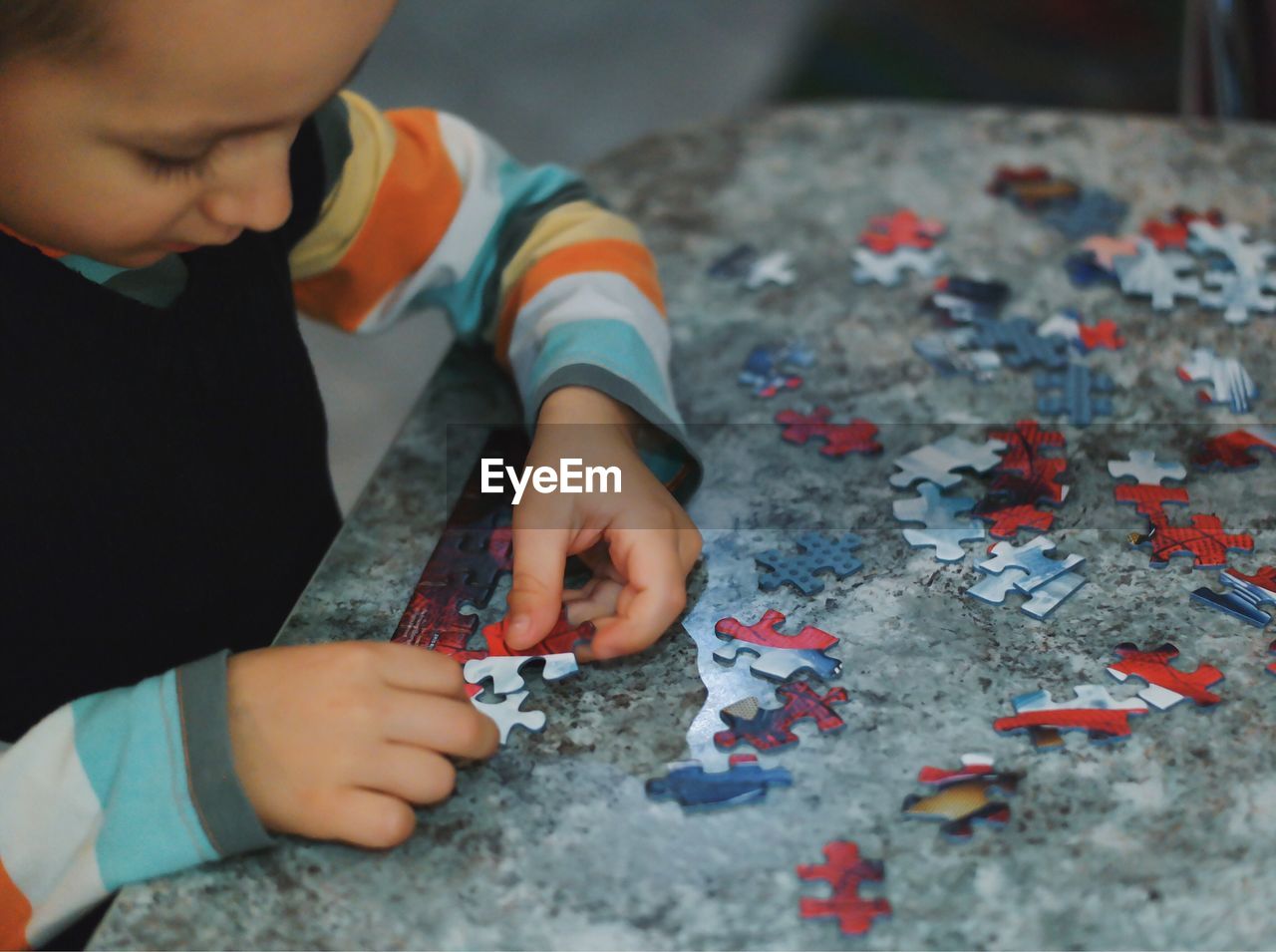 Boy playing puzzle game at table