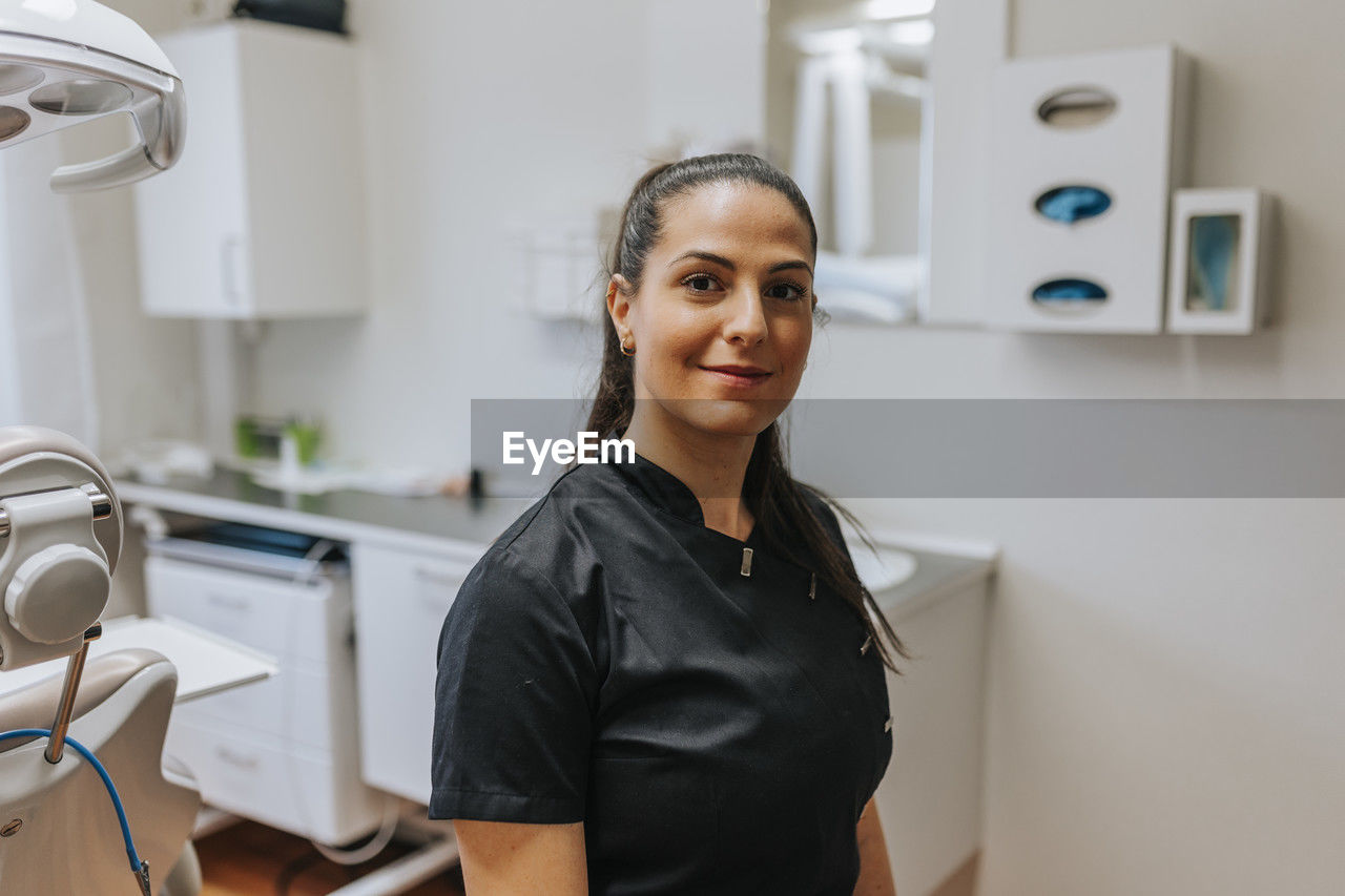 Female dentist standing in office