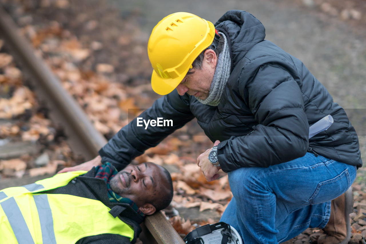 African american railroad engineer injured in an accident at work. coworker helping him