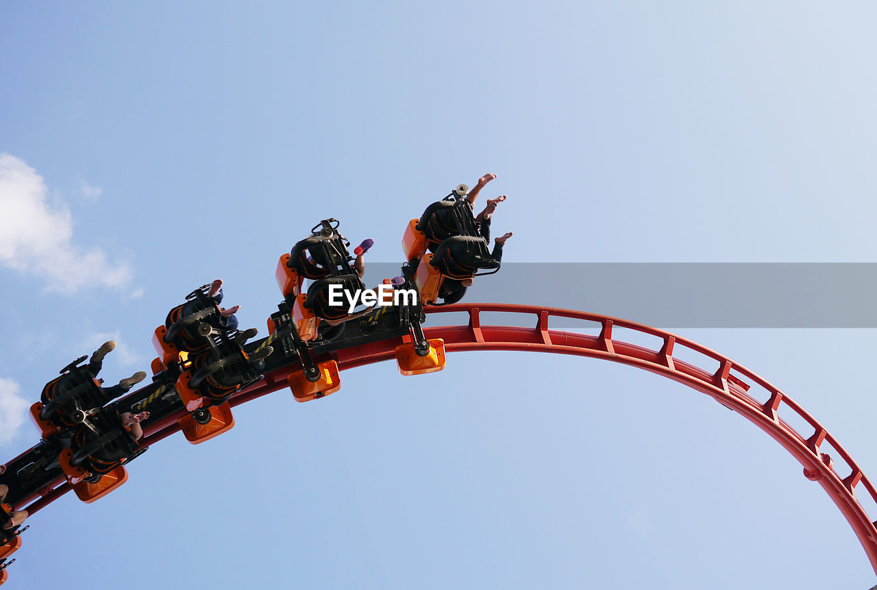 Low angle view of people riding on rollercoaster against sky