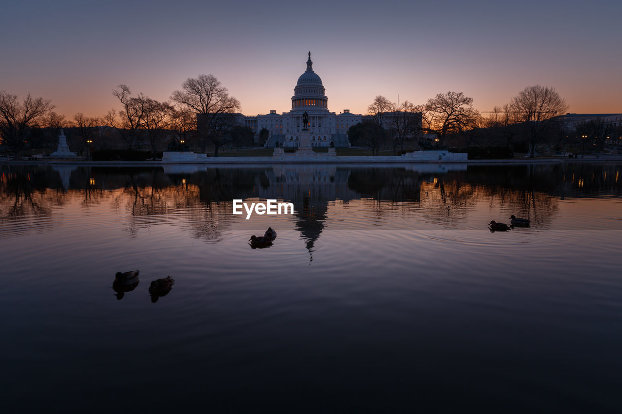 United states capital dome with reflection on river during sunrise