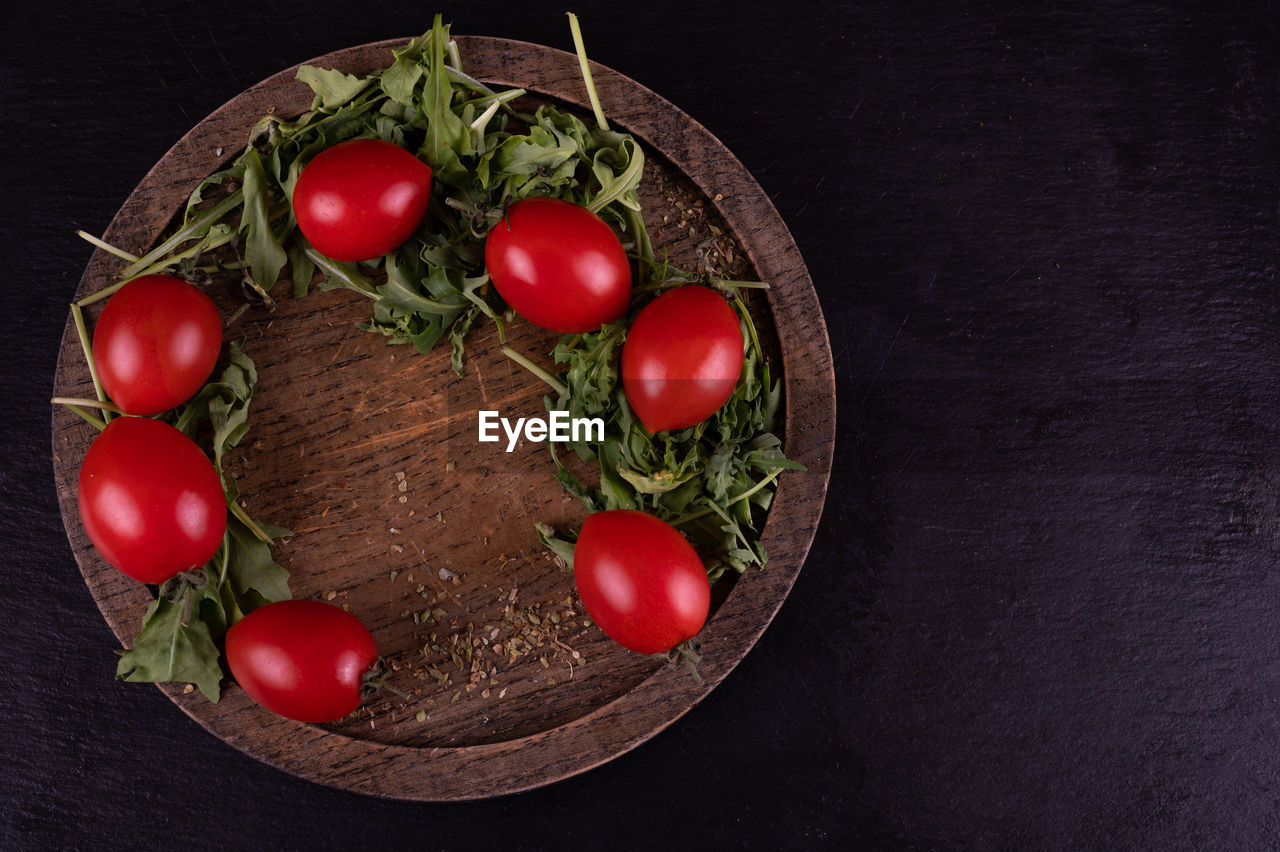 food, food and drink, tomato, healthy eating, vegetable, fruit, freshness, wellbeing, red, cherry tomato, indoors, studio shot, black background, no people, produce, wood, still life, plate, dark, directly above, plant, high angle view, herb, cherry, organic, nature, table, ingredient