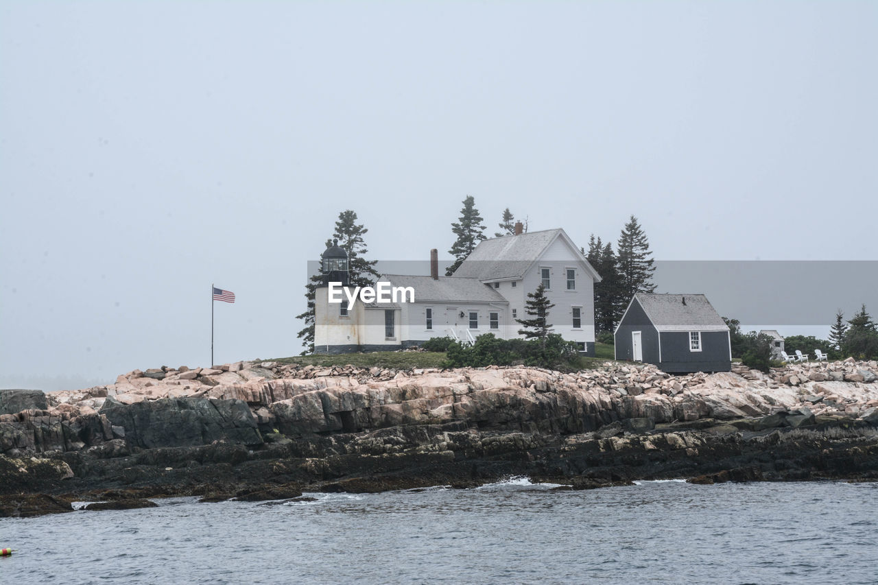 House by sea against clear sky