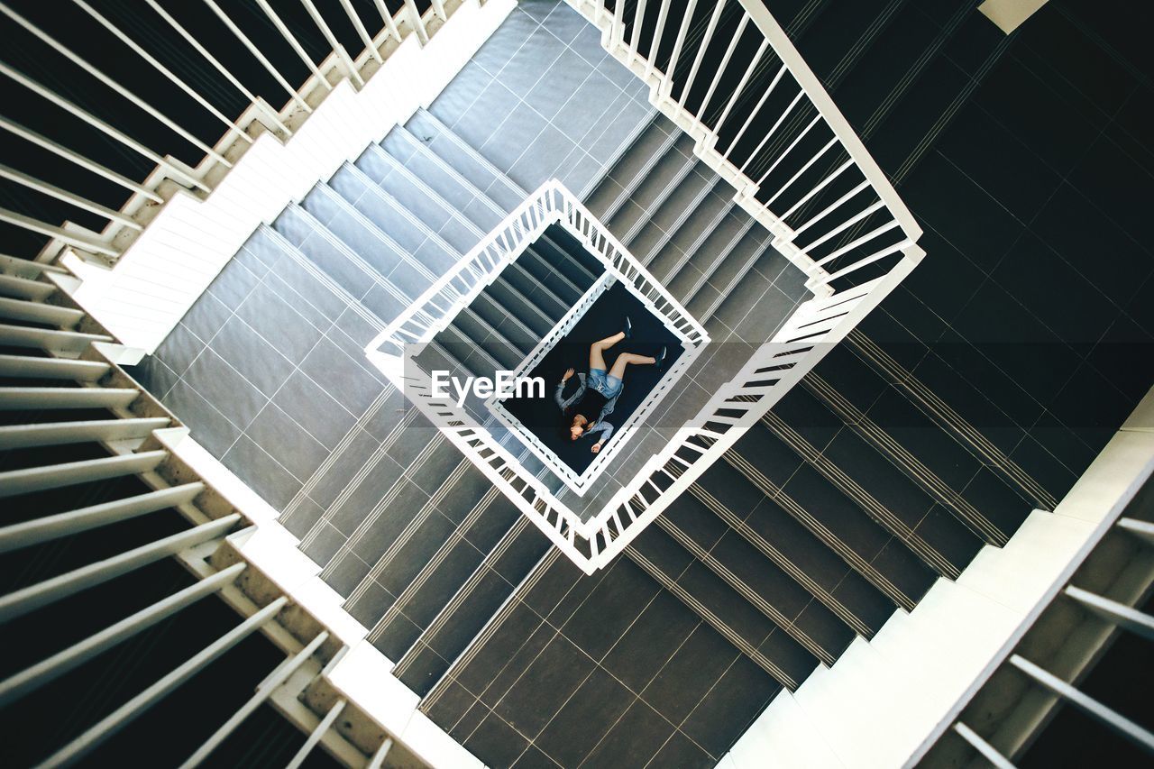 High angle view of stairs with woman lying on floor