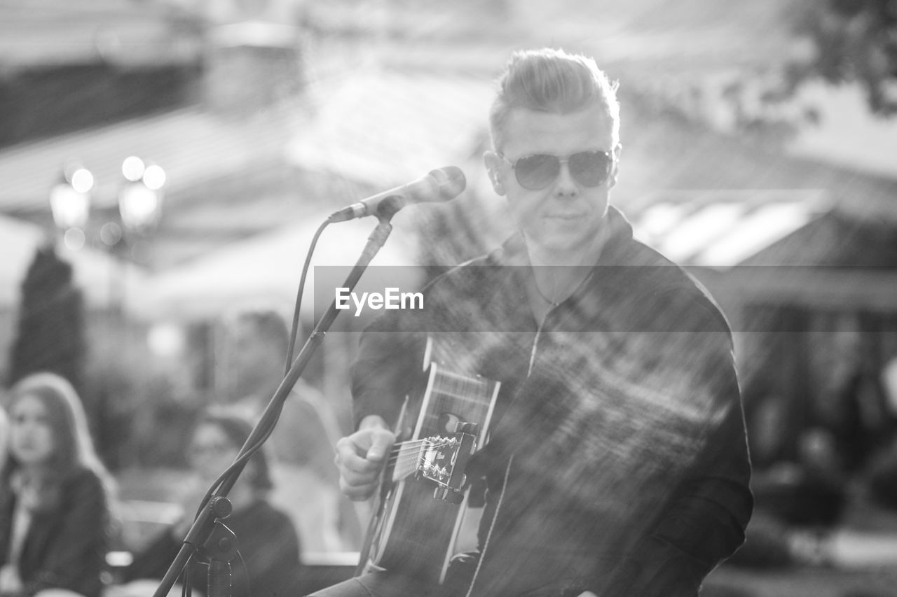 MAN HOLDING EYEGLASSES