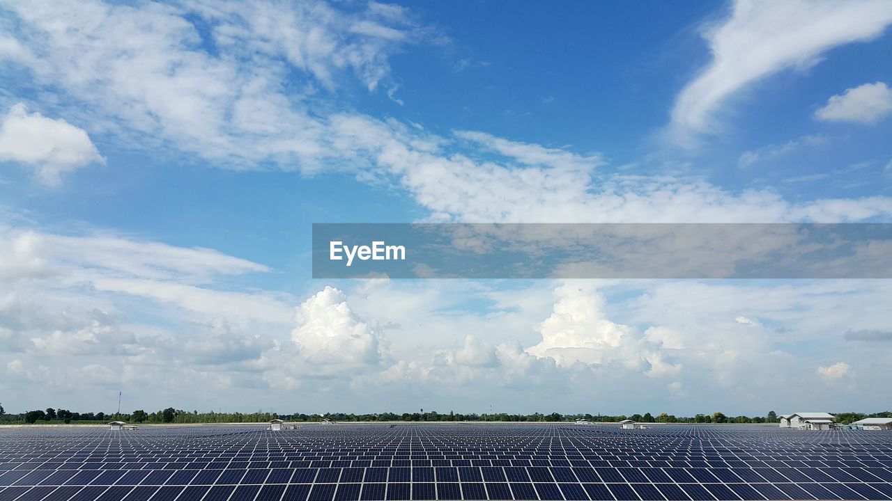 Solar panels on field against sky