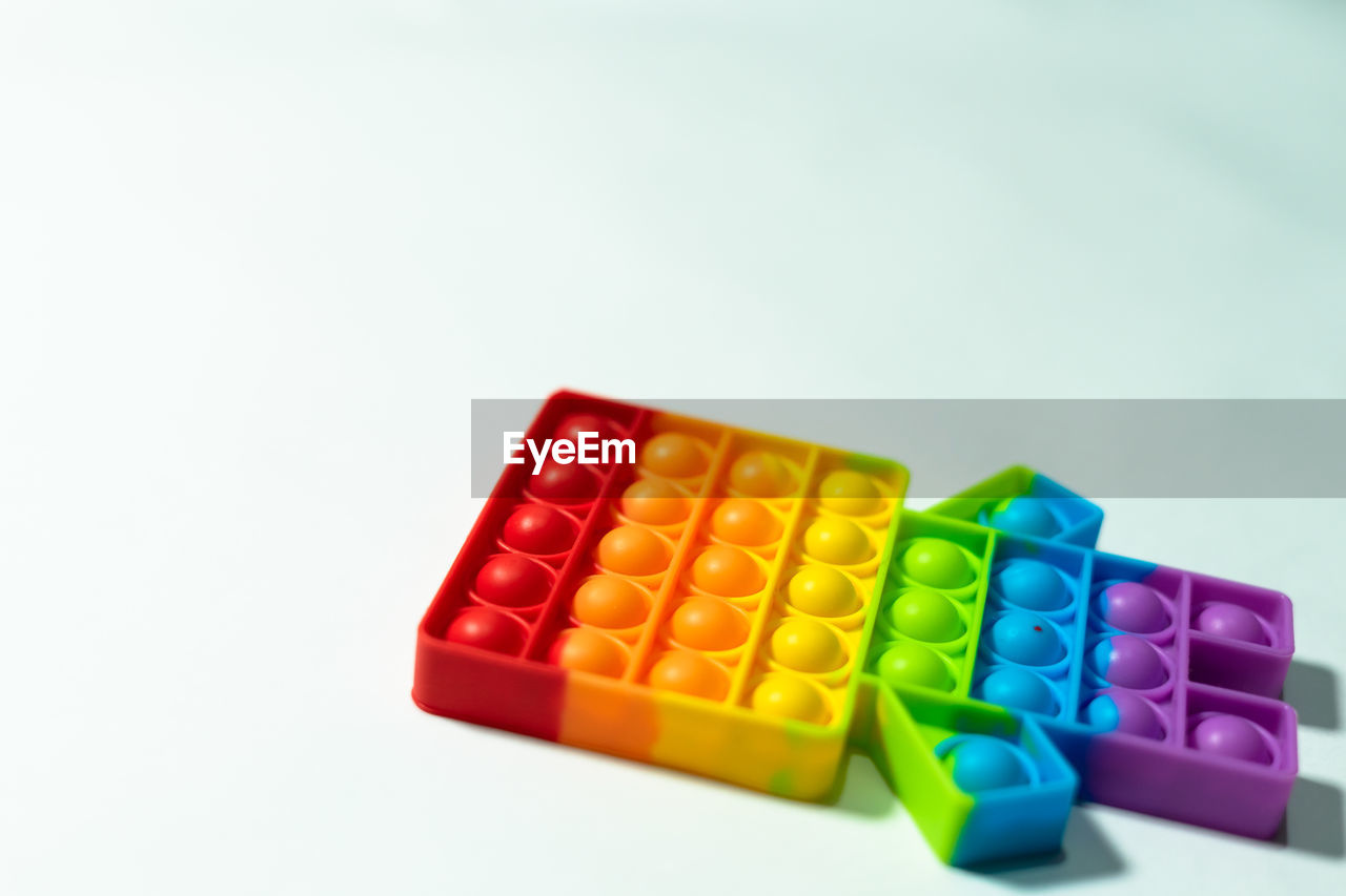 Rainbow pop it is an anti stress fidget toy for children and adults with space  on white background