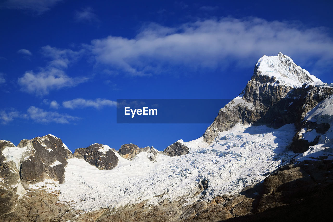 View of snowcapped mountain peak against cloudy sky