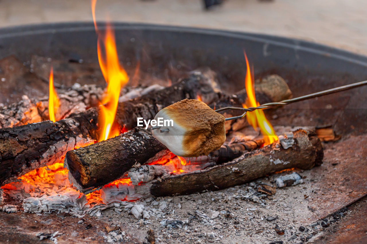 Toasting marshmallows over campfire in the summertime