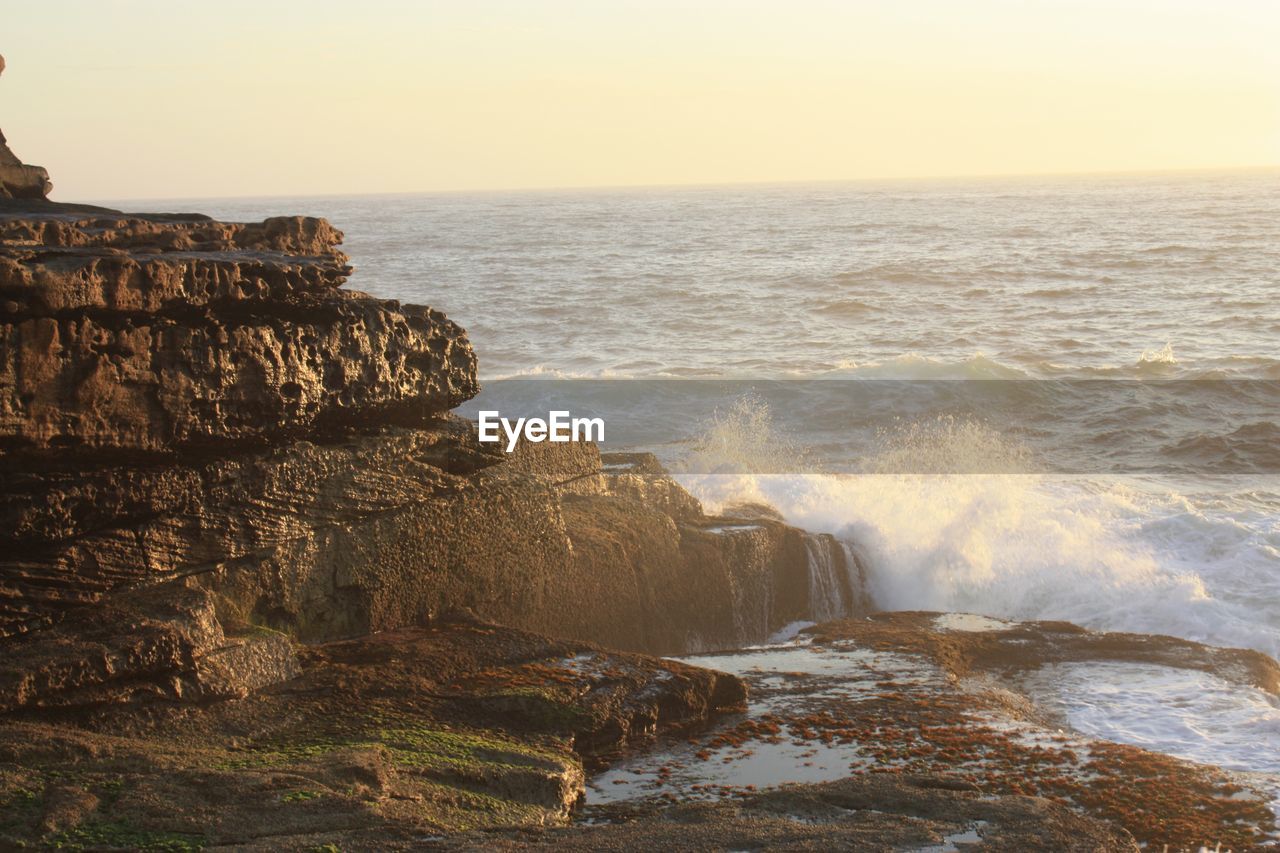 SCENIC VIEW OF SEA BY CLIFF AGAINST CLEAR SKY