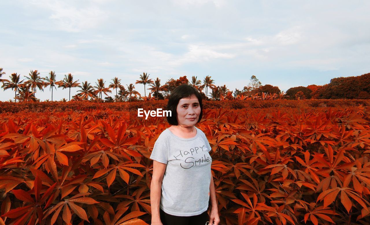 Portrait of smiling girl standing on land against sky