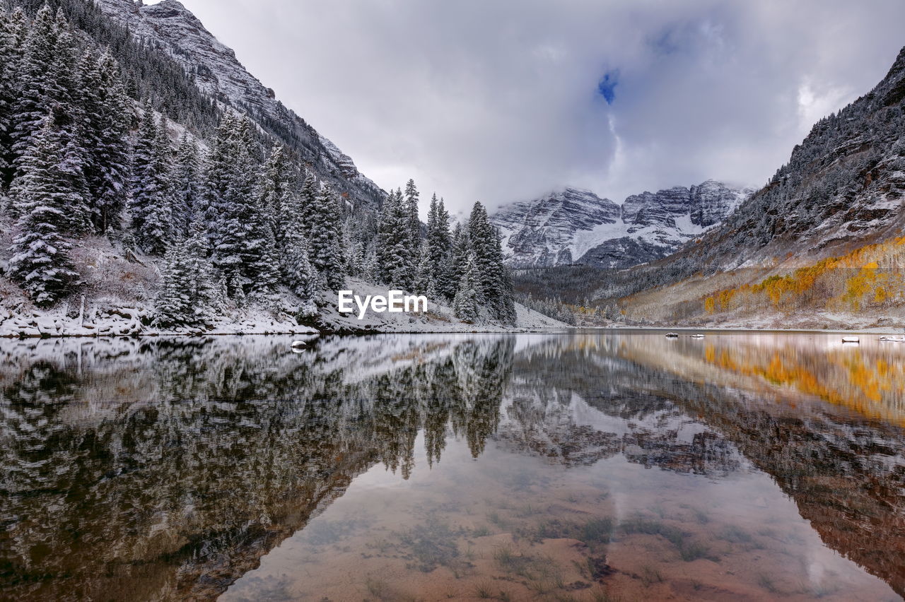 Scenic view of maroon lake and snowcapped mountains against cloudy sky