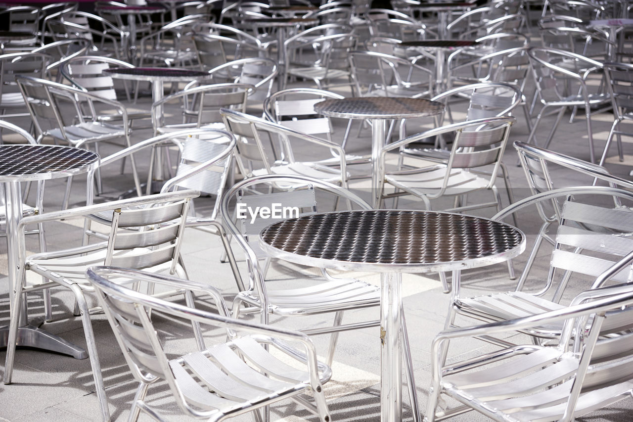 Background of aluminium tables and chairs set up at an outdoor event