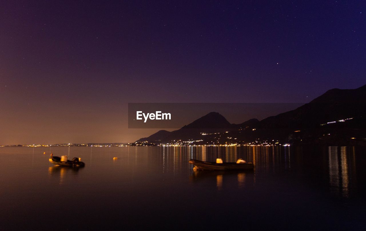 Scenic view of sea against clear sky at night - lago di garda 