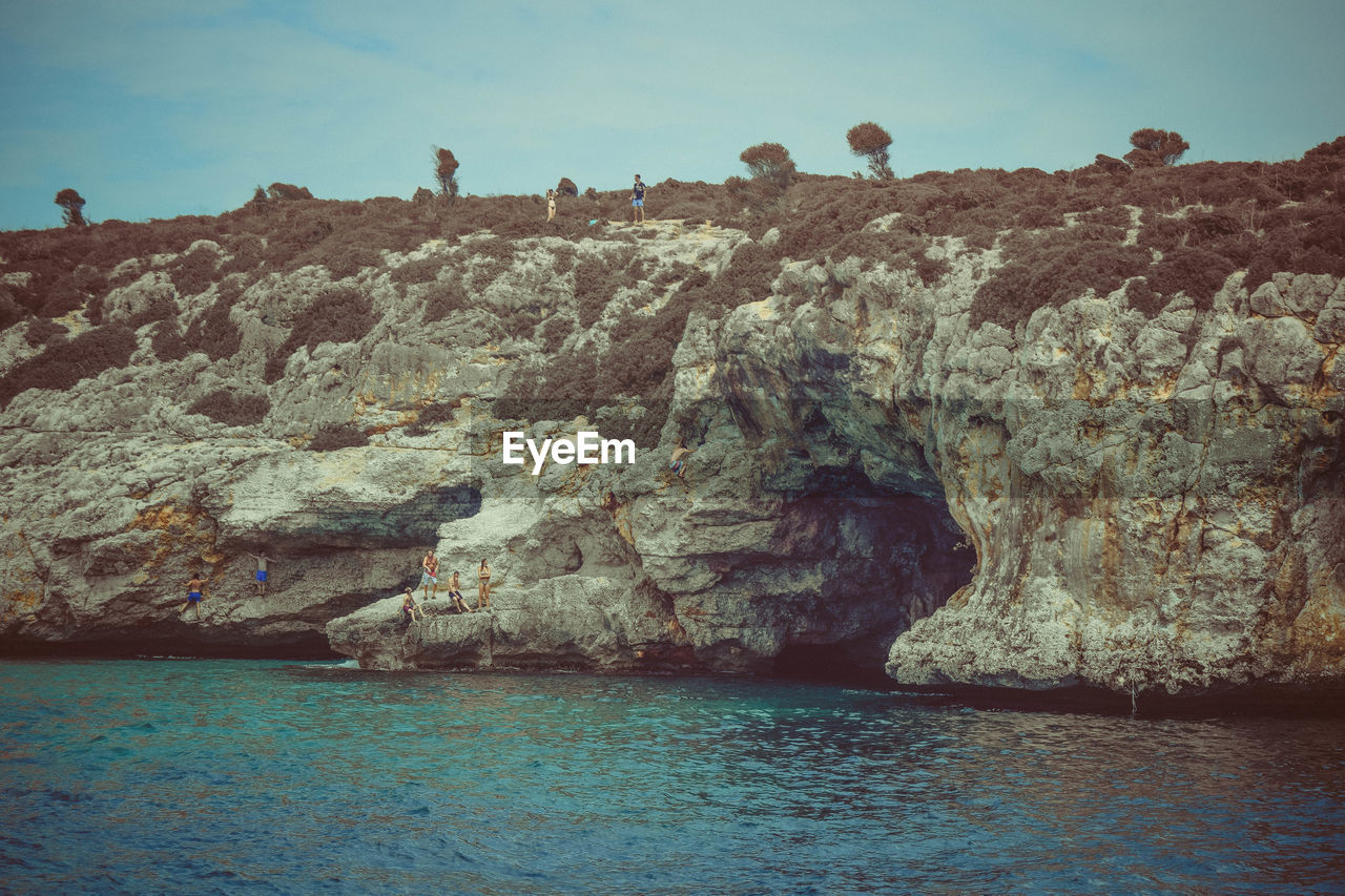 ROCK FORMATIONS ON SHORE AGAINST SKY