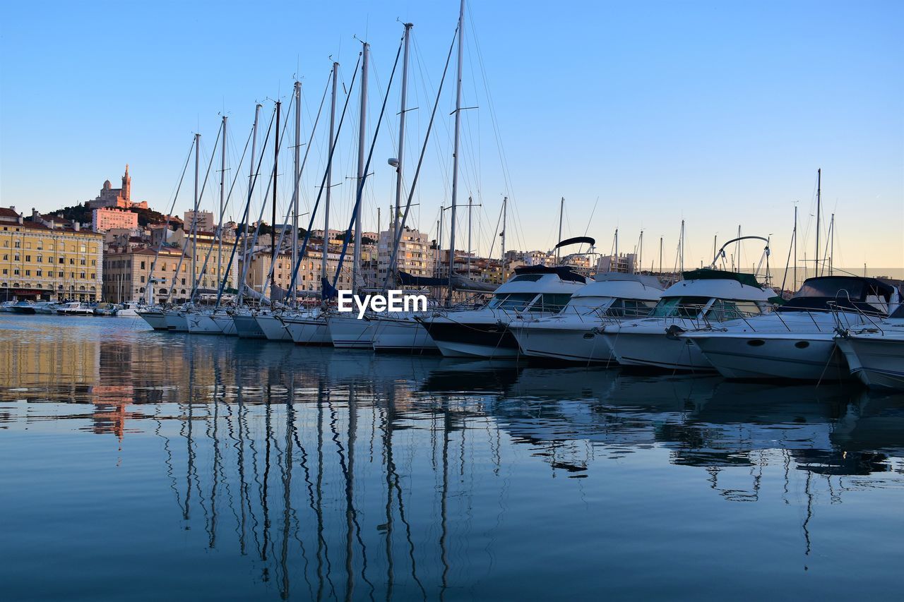 Sailboats moored in harbor