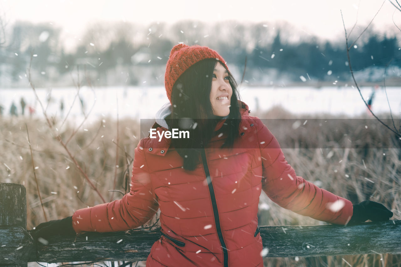 Woman standing on snow covered field during winter