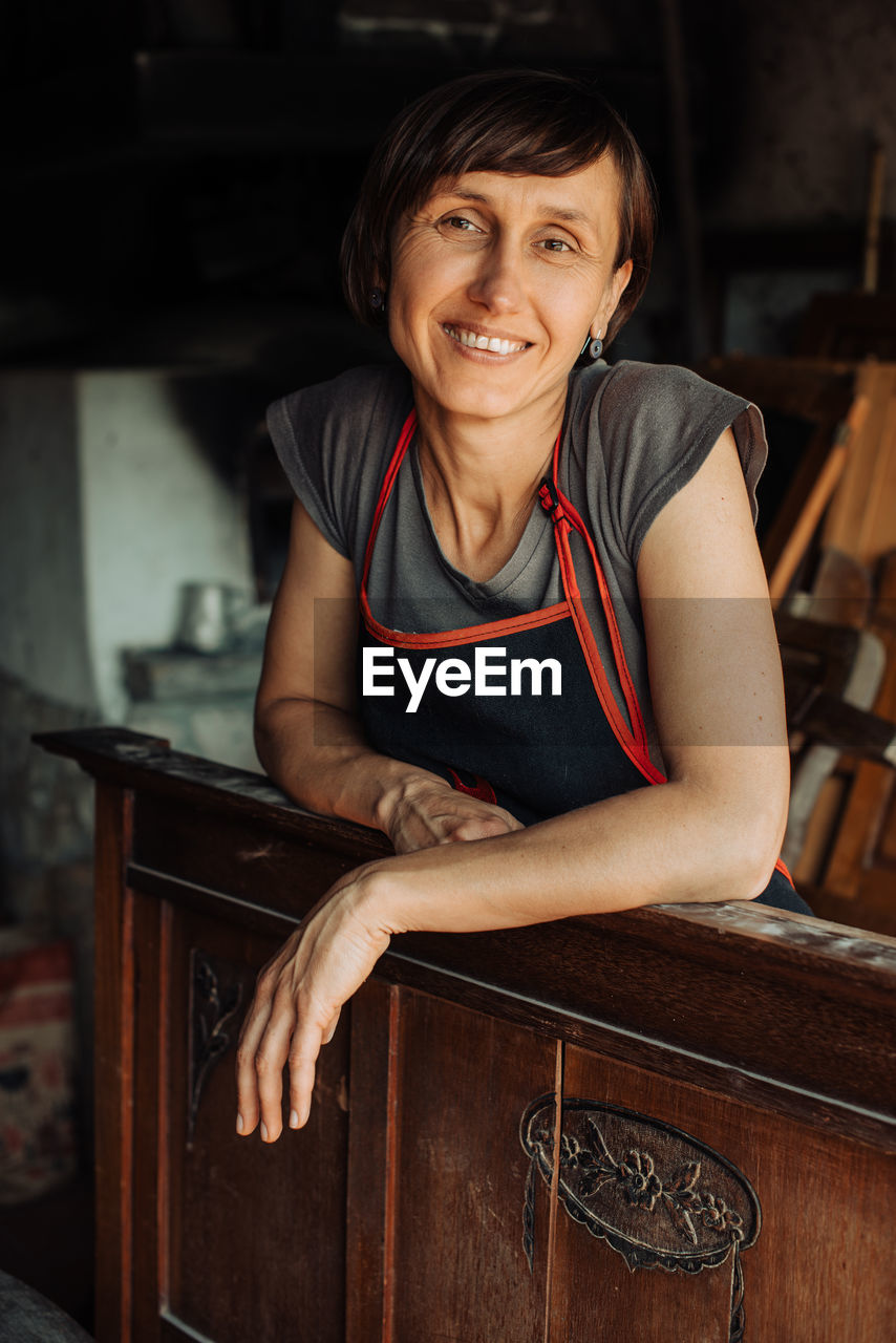 Professional female restorer or carpenter looking at camera, smiling