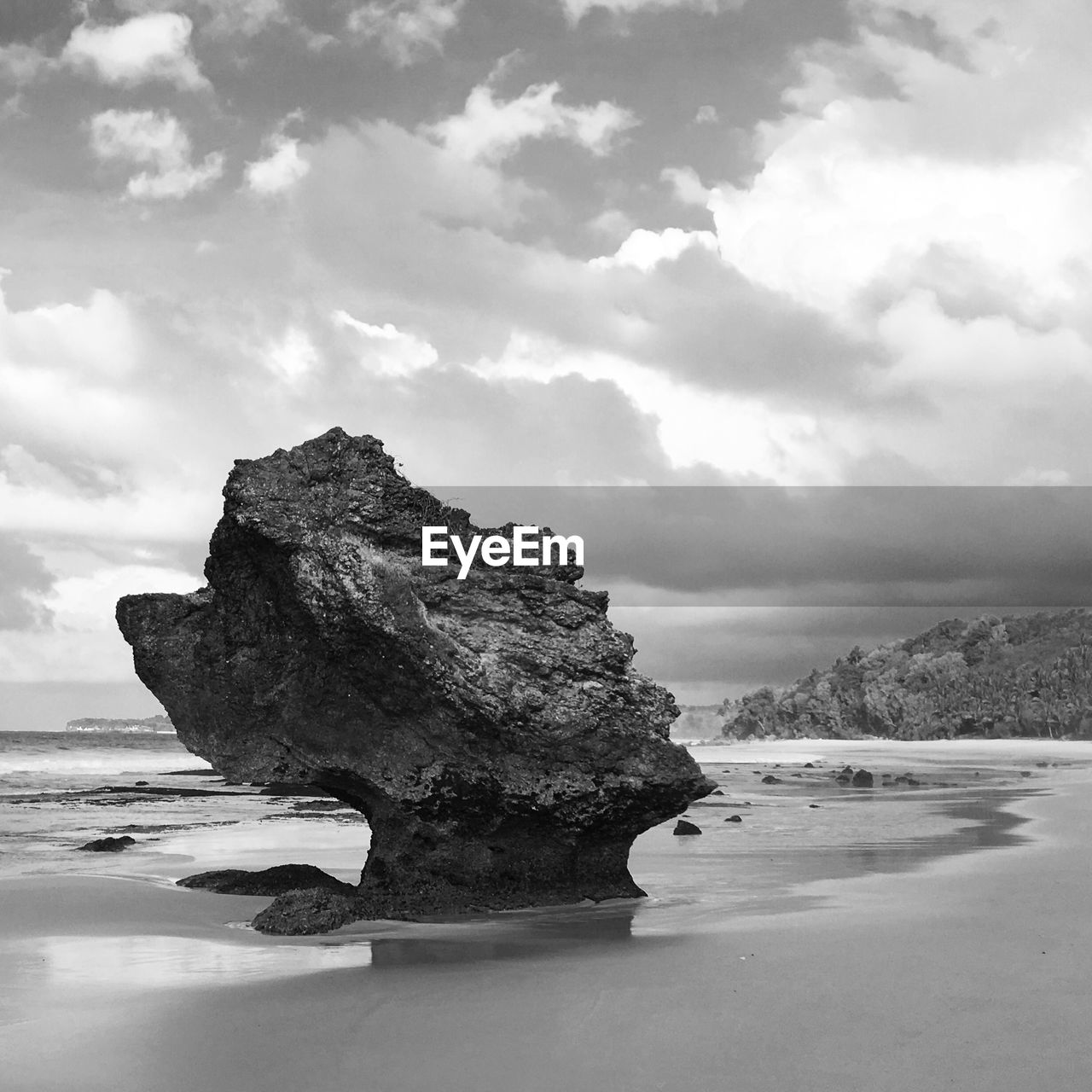 Rock formation at beach against sky